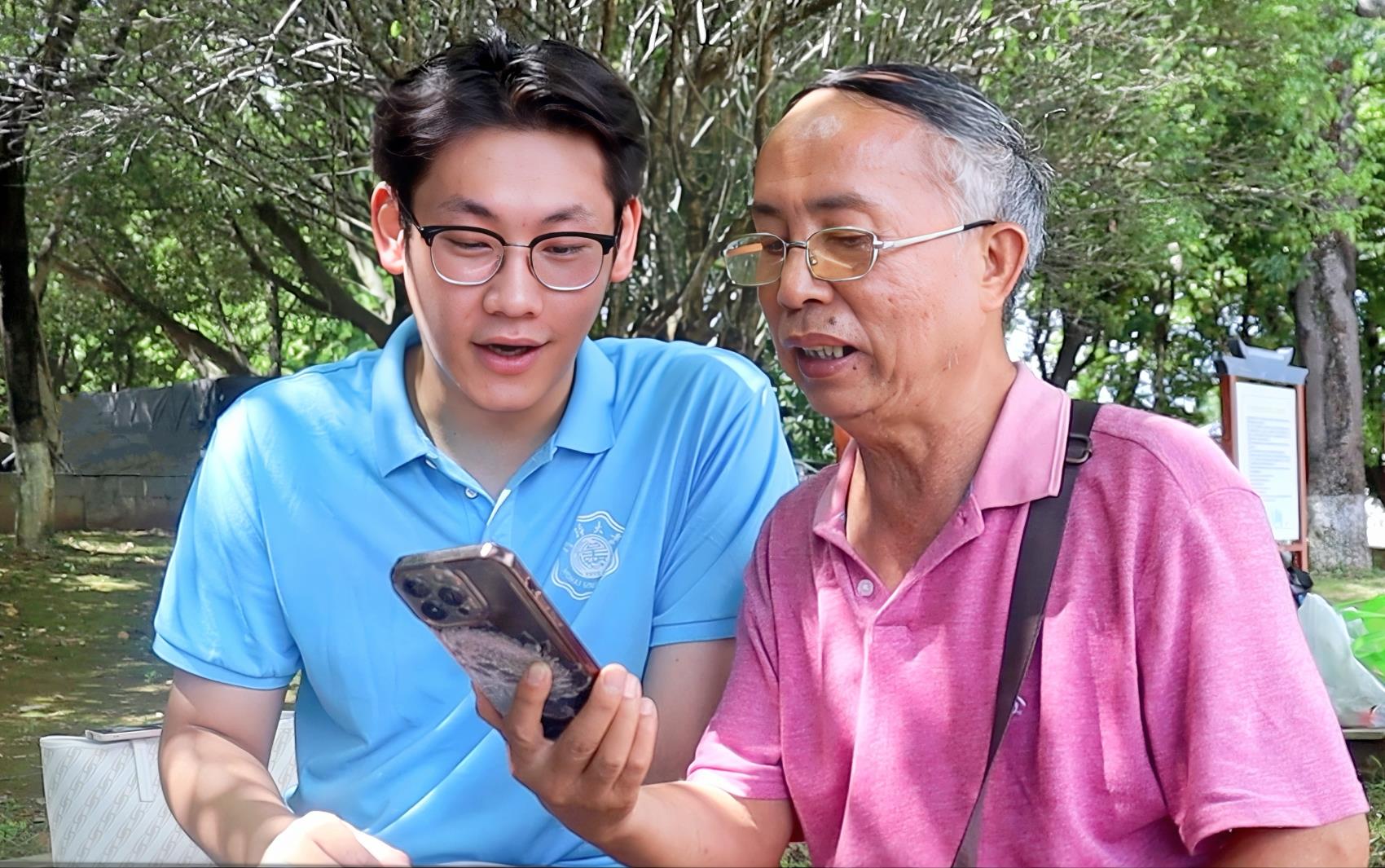 圖為實踐團成員與當(dāng)?shù)乩先艘黄饘W(xué)習(xí)誦讀古詩